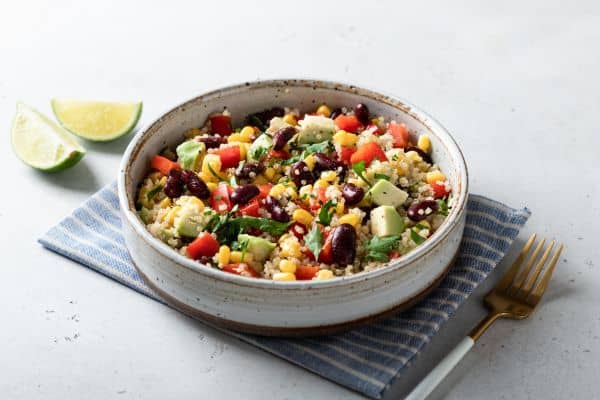 plato de quinoa, judías negras, tomate, maiz, cebolla roja y aguacate.