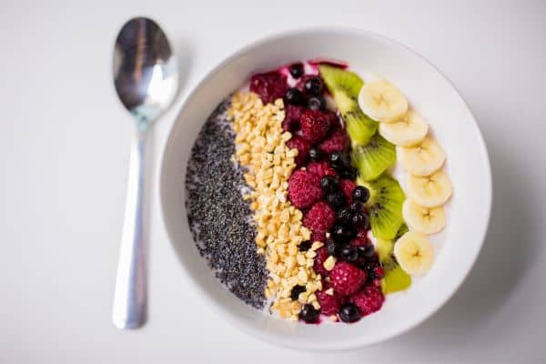 Tazón de desayuno con chía, lino molido, frutos rojos, kiwi y plátano