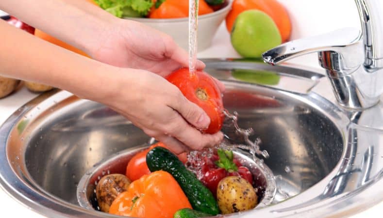 Lavar las verduras bajo el grifo de agua