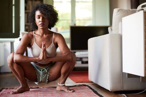 Mujer meditando en cuclillas